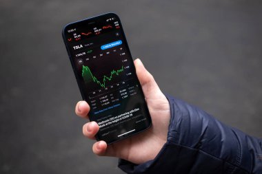 Kharkov, Ukrayna - 1 Aralık 2021: Tesla TSLA borsası. Finansal grafikler, yatırım, dijital bankacılık konsepti fotoğrafı. Elinde borsa uygulaması olan akıllı telefon. 
