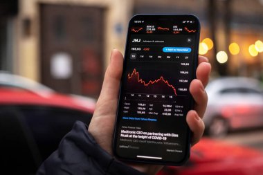 Kharkov, Ukrayna - 1 Aralık 2021: Johnson ve Johnson JNJ borsası. Finansal grafikler, yatırım, dijital bankacılık konsepti fotoğrafı. Elinde borsa uygulaması olan akıllı telefon. 