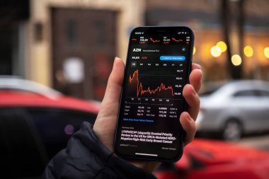 Kharkov, Ukrayna - 1 Aralık 2021: AstraZeneca borsası. Finansal grafikler, yatırım, dijital bankacılık konsepti fotoğrafı. Elinde borsa uygulaması olan akıllı telefon. 