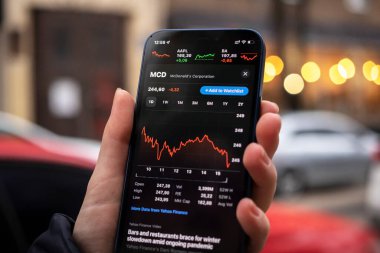 Harkov, Ukrayna - 1 Aralık 2021: McDonald 's MCD hisse senedi ticareti. Finansal grafikler, yatırım, dijital bankacılık konsepti fotoğrafı. Elinde borsa uygulaması olan akıllı telefon. 