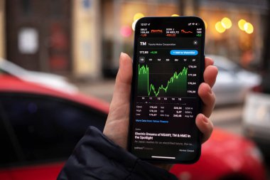 Harkov, Ukrayna - 1 Aralık 2021: Toyota TM hisse senedi ticareti. Finansal grafikler, yatırım, dijital bankacılık konsepti fotoğrafı. Elinde borsa uygulaması olan akıllı telefon. 