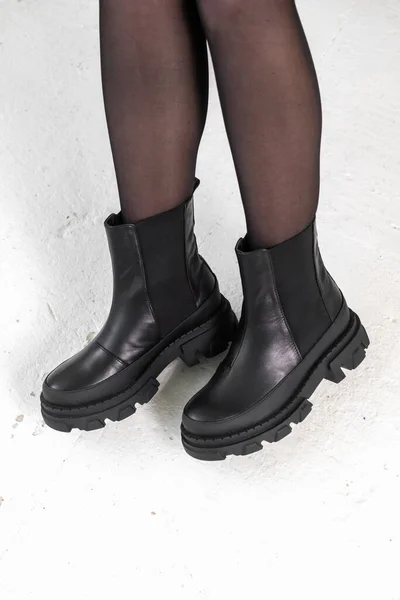 Negro zapatos elegantes en las piernas de las mujeres. Botas de invierno de cuero, foto elegante del concepto de calzado de señora —  Fotos de Stock