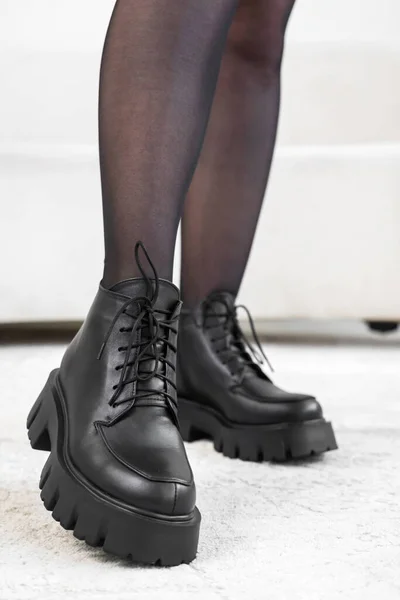 Zbliżenie czarne eleganckie buty na kobiecych nogach. Skórzane buty zimowe, stylowa koncepcja obuwia damskiego — Zdjęcie stockowe