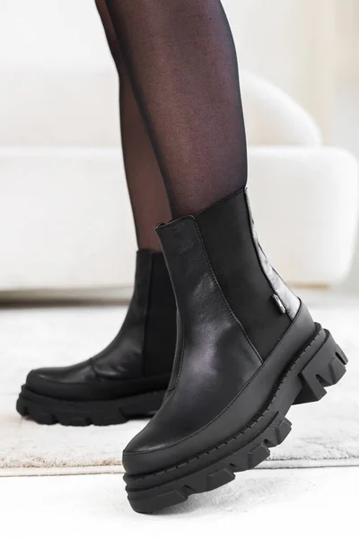 Primeros planos zapatos elegantes negros en las piernas de las mujeres. Botas de invierno de cuero, elegante concepto de calzado de señora —  Fotos de Stock