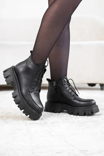 Primeros planos zapatos elegantes negros en las piernas de las mujeres. Botas de invierno de cuero, elegante concepto de calzado de señora —  Fotos de Stock