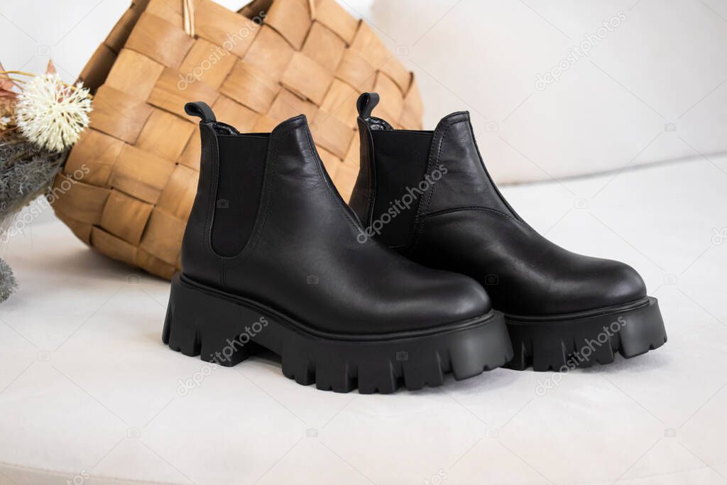 Closeup black winter shoes. Women's leather boots with natural materials 