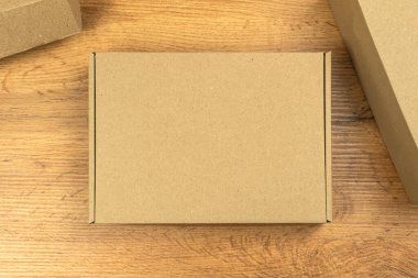 Kahverengi karton kutu ahşap masada, depo arka planında. Model, dağıtım konsepti ve ürünlerinizi nakliye vs..