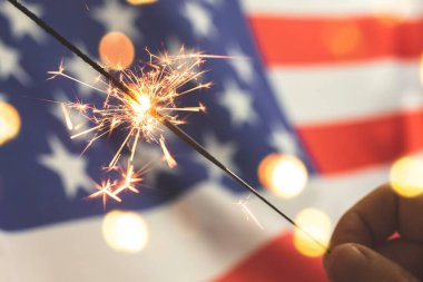 Amerikan bayrağı ve maytap elinde. ABD, 4 Temmuz kutlamaları