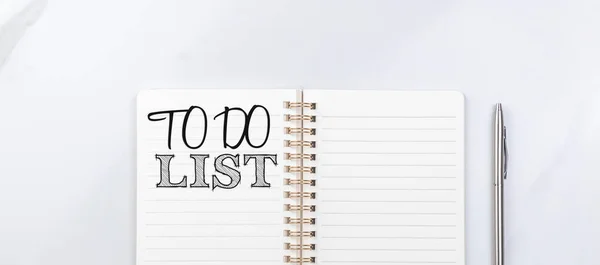 To do list for next year, banner. Empty notebook on white table with silver pen. Top view