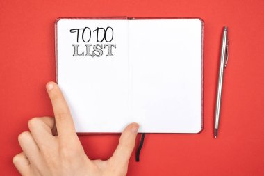 Yapılacaklar listesi olan bir defter. Yeni yıl konsepti planlıyorum. Kırmızı arkaplan, gümüş kalem, kopyalama alanı ve üst görünüm