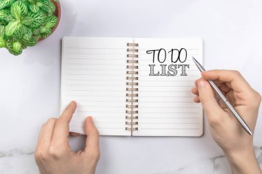 Gelecek yılın yapılacaklar listesi. Ofis masaüstü, gümüş kalemli beyaz masa. Üst görünüm