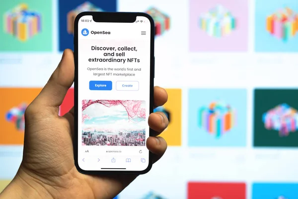 Kharkov, Ukrayna - 17 Aralık 2021: Adam NFT satışı için OpenSea pazarını kullanıyor. Cep telefonu ekranında logosu olan bir site. Kriptoart, dijital sanatlar ve koleksiyonlar kavramı 