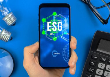 ESG konsepti. Sürdürülebilir ve etik sektörde çevre, sosyal ve yönetim. Modern akıllı telefon masada. Ekoloji bakımı