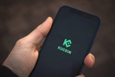 Kharkov, Ukrayna - 25 Aralık 2021: Apple iPhone 12 'de KuCoin Cüzdan uygulaması kullanılıyor. Başlık ekranı kapatma, şifreleme ve NFT konsepti