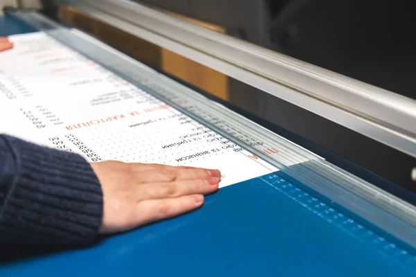 Trabajador con máquina cortadora de papel en imprenta. Fondo de la industria de impresión — Foto de Stock