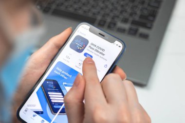 Kharkov, Ukraine - January 10, 2022: GHA COVID Pass Gibraltar app icon closeup. Woman uses the application on Apple iPhone 12