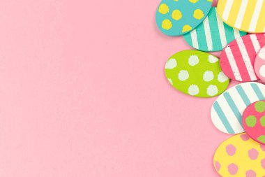 Colorful easter eggs on a bright pink background. Flat lay celebration greeting design, border concept, copy space and top view 
