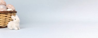 Easter bunny with basket full of easter eggs. Banner. Spring holiday concept, copy space 