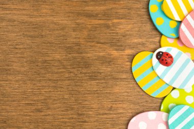 Colorful Easter eggs border, old rustic wood background, flat lay design, top view with copy space