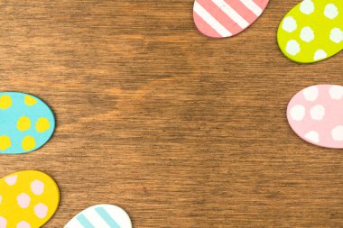 Colorful Easter eggs double side border, old rustic wood background, flat lay design, top view with copy space