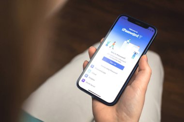 Kharkov, Ukrayna - 10 Ocak 2022: Kadın 1Parola uygulaması kullanıyor. Apple iPhone 12 ile el, logolu cep telefonu ekranı