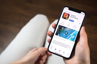 Kharkov, Ukrayna - 19 Ocak 2022: XCOM oyun uygulaması. Elinde cep telefonu olan bir kız oyun oynamak istiyor. Popüler mobil oyunlar konsepti 