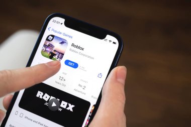 Kharkov, Ukrayna - 19 Ocak 2022: Roblox oyun uygulaması. Elinde cep telefonu olan bir kız oyun oynamak istiyor. Popüler mobil oyunlar konsepti 
