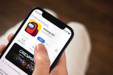 Kharkov, Ukrayna - 19 Ocak 2022: Aramızdaki oyun uygulaması. Elinde cep telefonu olan bir kız oyun oynamak istiyor. Popüler mobil oyunlar konsepti