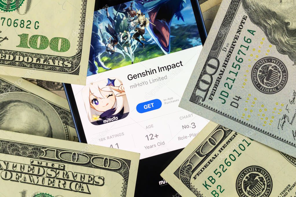 Kharkov, Ukraine - January 19, 2022: Genshin Impact mobile game app and money background photo