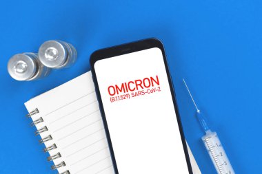 Coronavirus Omicron B.1.529 mutasyonu. Şırınga ve aşı şişeleriyle tıbbi masa arkası, aşı fotoğrafı konsepti