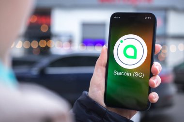 Kharkov, Ukrayna - 2 Şubat 2022: Siacoin SC sembolü. Şifreli para ticareti, dijital ve sanal para, mobil bankacılık. Akıllı telefon ile el, kripto simgesi ile ekran yakın çekim