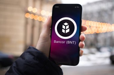 Kharkov, Ukrayna - 2 Şubat 2022: Bankor BNT para sembolü. Şifreli para ticareti, dijital ve sanal para, mobil bankacılık. Akıllı telefon ile el, kripto simgesi ile ekran yakın çekim