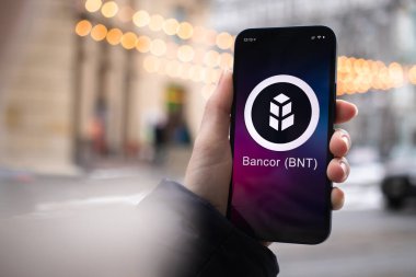 Kharkov, Ukrayna - 2 Şubat 2022: Bankor BNT para sembolü. Şifreli para ticareti, dijital ve sanal para, mobil bankacılık. Akıllı telefon ile el, kripto simgesi ile ekran yakın çekim