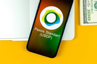Kharkov, Ukraine - January 31, 2022: Paxos Standart USDP coin symbol. Trade with cryptocurrency, digital and virtual money, banking with mobile phone concept. Business workspace, table with laptop clipart