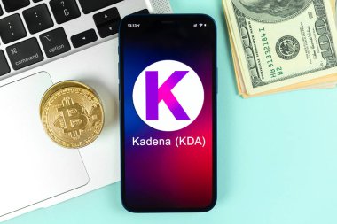 Kharkov, Ukrayna - 31 Ocak 2022: Kadena KDA madeni para sembolü. Şifreli para ticareti, dijital ve sanal para, cep telefonu konsepti ile bankacılık. Çalışma alanı, dizüstü bilgisayarı olan masa