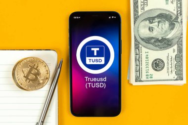 Harkov, Ukrayna - 31 Ocak 2022: TrueUSD madeni para sembolü. Şifreli para ticareti, dijital ve sanal para, cep telefonu konsepti ile bankacılık. Çalışma alanı, masa üstü görünümü 