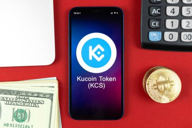 Kucoin KCS sembol. Şifreli para ticareti, dijital ve sanal para, cep telefonu konsepti ile bankacılık. Çalışma alanı, dizüstü bilgisayarlı fotoğraf tablosu