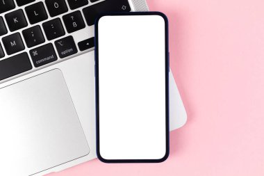 Düz kontak akıllı telefon modeli, bilgisayarlı ofis masaüstü, parlak pembe arka plan. Üst görünüm, alanı kopyala
