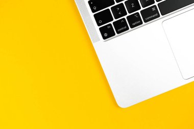 Modern dizüstü bilgisayar sarı arka plandaydı. Not defteri klavyesi. Ofis çalışma masası, asgari tasarım konsepti. Üst görünüm, alanı kopyala