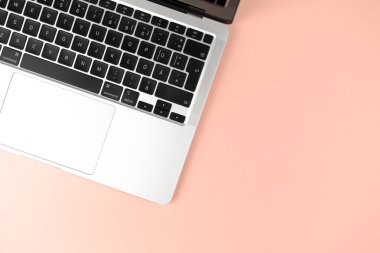 Modern laptop keyboard düz şeftali arkaplan yatıyordu. Ofis çalışma masası, asgari tasarım konsepti. Üst görünüm, alanı kopyala