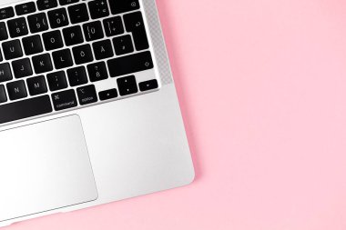 Modern dizüstü bilgisayar pembe arka plandaydı. Not defteri klavyesi. Ofis çalışma masası, asgari tasarım konsepti. Üst görünüm, alanı kopyala