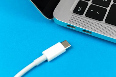 Günümüz USB tip C portu ile bilgisayarı şarj ediliyor. Laptop düşük pil konsepti, teknoloji arka planı, ofis masası üstü görünümü 