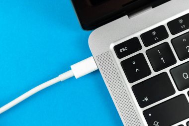 Günümüz USB tip C portu ile bilgisayarı şarj ediliyor. Laptop düşük pil konsepti, teknoloji arka planı, ofis masası üstü görünümü 
