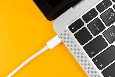 Günümüz USB tip C portu ile bilgisayarı şarj ediliyor. Laptop düşük pil konsepti, teknoloji arka planı, ofis masası üstü görünümü