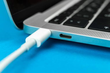 Günümüz USB tip C portu ile bilgisayarı şarj ediliyor. Laptop düşük pil konsepti, teknoloji arka planı, ofis masası üstü görünümü 