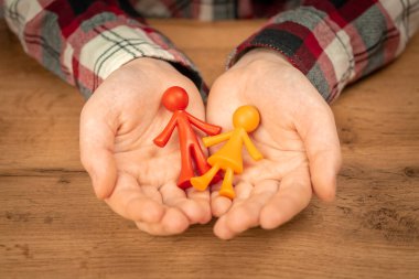 Çocuksuz genç aile figürleri insan ellerinde. Aile değerleri kavramı