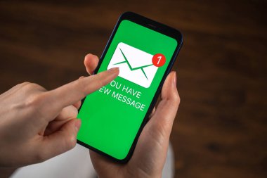 Akıllı telefon ve yeni mesaj ikonu yakın plan. Yeni tebligat ve iş geçmişine sahip cep telefonu kullanan kadın