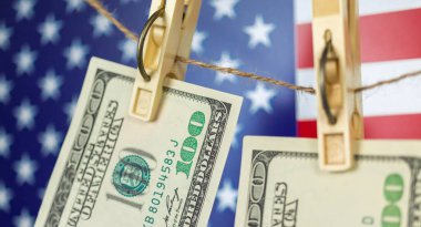 Para aklama konsepti için ipte asılı duran Amerikan doları banknotları. ABD ulusal bayrağı arkaplan, yakın plan görünüm