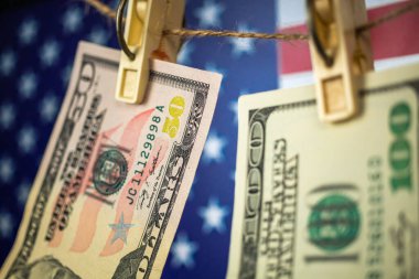 Para aklama konsepti için ipte asılı duran Amerikan doları banknotları. ABD ulusal bayrağı arka planı, yakın çekim fotoğrafı