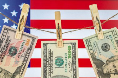 Amerikan bayrağında kara para aklama ve Amerikan doları kurumaya bırakıldı. Dolar banknotları çamaşır ipine asılı, yakın plan fotoğraf